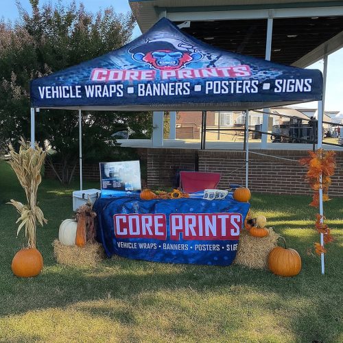 Core Prints fall trade show booths setup with branded canopy, table cover, pumpkins, and hay bale accents.