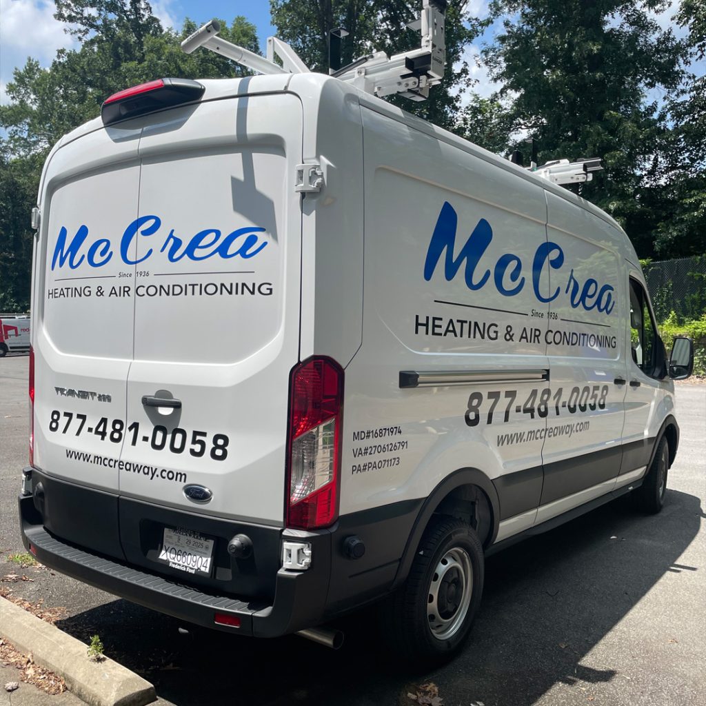 White Ford Transit van wrapped for McCrea Heating & Air Conditioning with blue lettering and contact details applied by Core Prints in Fredericksburg, Virginia.