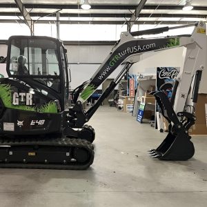 Custom vinyl wrap for GTR Turf USA excavator with black and green design featuring grass patterns and company website, created by Core Prints.